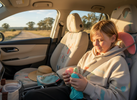 “Bright, playful car interior in soft morning daylight with a child/teen buckled in the back seat calmly using a quiet sensory fidget.”