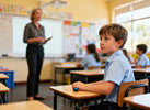 Primary school classroom scene with a teacher at the front while a student quietly uses a small discreet fidget at their desk, calm and focused
