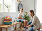 Parent helping a school-aged child put on shoes by the front door while the child holds a small fidget, with a basket of quiet sensory tools nearby