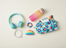 Bright, playful flat lay of a teenager’s sensory toolkit: pencil case, headphones, water bottle, and a small colourful sensory fidget on a clean background