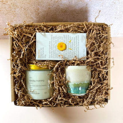 SUNDAY MORNING GIFT BOX with candle, ceramic cup, and herbal tea in eco-friendly packaging, helping families thrive.