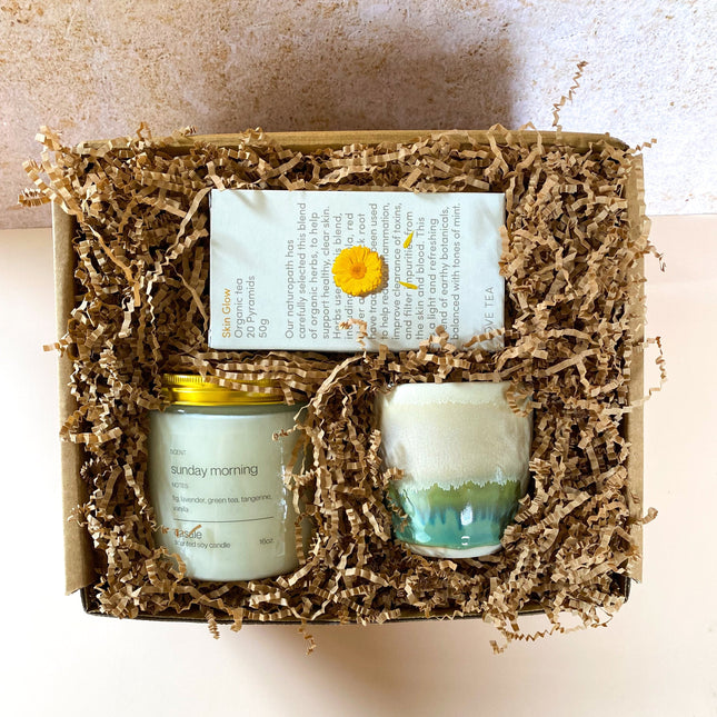 SUNDAY MORNING GIFT BOX with candle, ceramic cup, and herbal tea in eco-friendly packaging, helping families thrive.