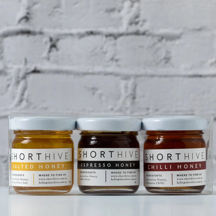 Clear glass jars of salted, espresso, and chili honey in a Honeylight Gift Box for sensory wellbeing.