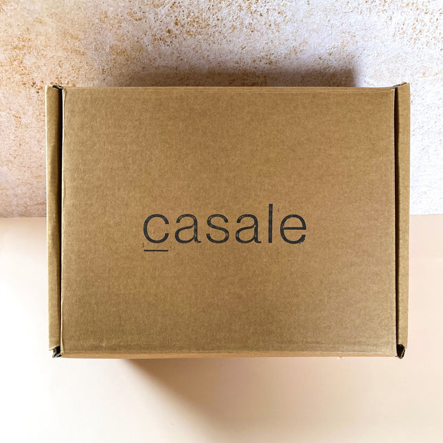 Closed brown cardboard box with Casale logo, containing the SUNDAY MORNING GIFT BOX to calm, connect and support.