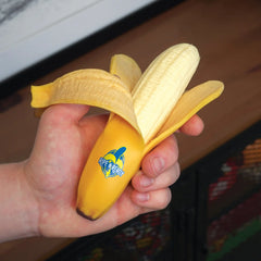 Hand holding Bubblegum Stuff - Ripe N Ready Stress Banana squishy toy helping families thrive with calm support