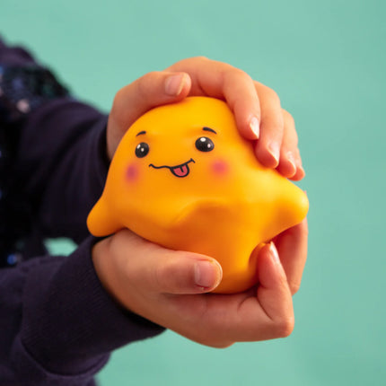 Child holding a bright yellow Stress Toy - Jellysquish with a playful face, promoting calm and focus.