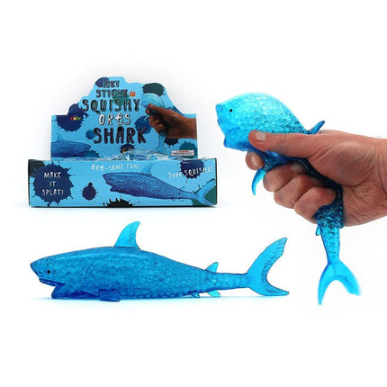 Hand squeezing a blue Squishy Water Orbs Shark sensory toy with textured water beads inside for fidgeting.