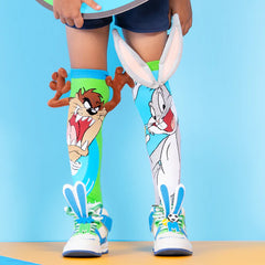Child wearing colorful Bugs Bunny Socks with 3D ears and Taz character, helping families thrive with tools to calm connect and support