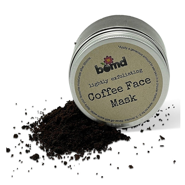 Tin container of Fresh face Coffee Scrub Face Mask - Lightly Exfoliating Face Masque with spilled coffee grounds on white background