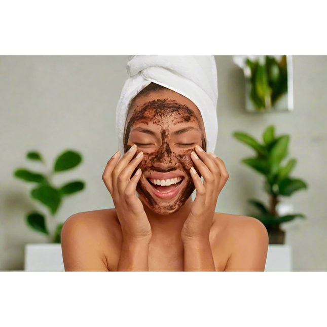 Smiling woman with towel on head applying Fresh face Coffee Scrub Face Mask - Lightly Exfoliating Face Masque, calming skincare.