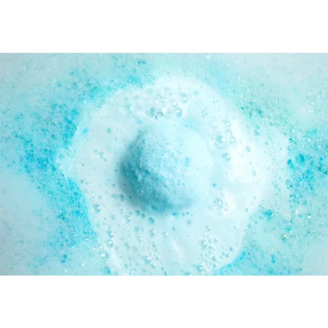 Mermaid Kisses Summer Coconut & Lime Bubble Bath Bomb dissolving in blue foamy water, helping families thrive with tools to calm, connect and support