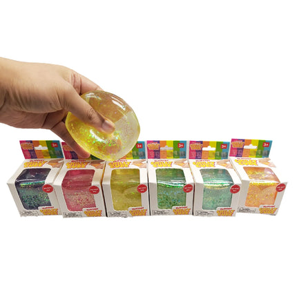 Chilly Cube Glittery sensory squishy held above colorful packaged glitter toys