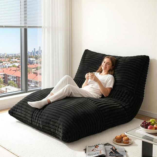 Woman relaxing on Artiss 3-in-1 Bean Bag Chair for Living Room Convertible Floor Sofa Dark Grey by a window in a bright room