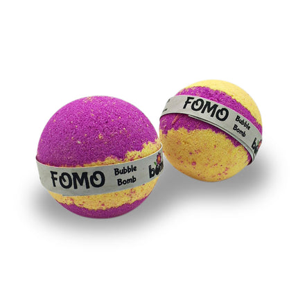 Two FOMO Fun Fizzy Colourful Bubble Bath Bombs in purple and yellow with branded labels on white background