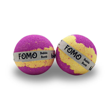 Two FOMO Fun Fizzy Colourful Bubble Bath Bombs in purple and yellow, helping families thrive with tools to calm, connect and support
