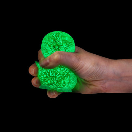 Smoosho's Super Squeeze Glow-in-the-dark Penguin being squeezed in a hand