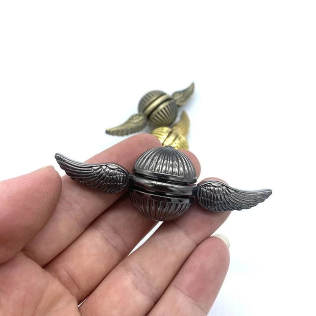 Hand holding a Harry Potter Snitch Metal Fidget Spinner with winged design, calming sensory fidget tool.