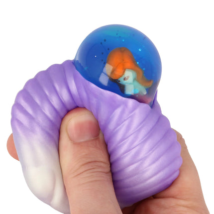 Hand squeezing a purple textured squishy with a blue bubble containing a small mermaid figure, Squishy Mermaid Bubble Shells.