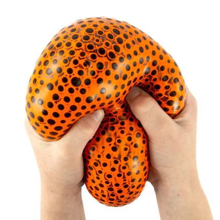 Hands squeezing an orange and black dotted Beadz Alive Giant Ball sensory fidget toy for stress relief.