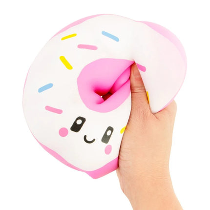 Hand squeezing a pink and white frosted donut-shaped sensory toy with a smiling face