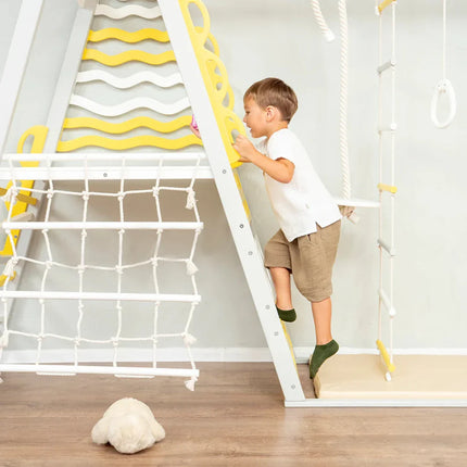 Child climbing the Wooden Teepee Playground indoor gym with yellow and white sensory features
