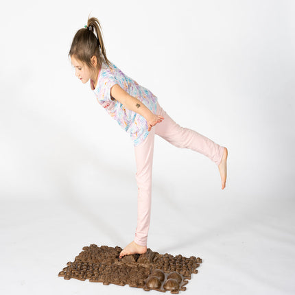 Child balancing barefoot on textured brown Muffik Eco Sensory Playmat - Individual for sensory play and calm focus