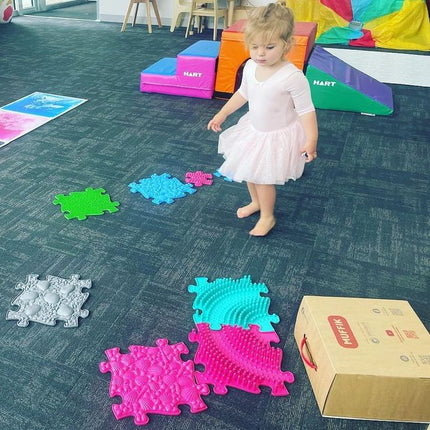 Child playing barefoot on colorful Large 2 Tactile Sensory floor mats set with varied textured surfaces