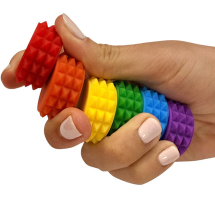 Hand holding colorful textured pieces of the MagStak Core - Textured sensory fidget toy set