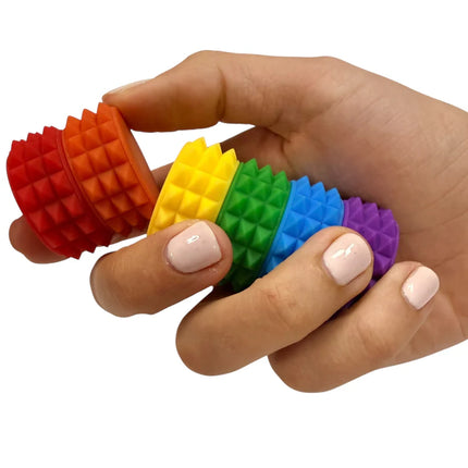 Hand holding colorful textured rings fidget toy designed for sensory play called MagStak Core - Textured