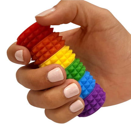 Hand holding MagStak Core - Textured rainbow sensory fidget toy with tactile pyramid patterns for stress relief.