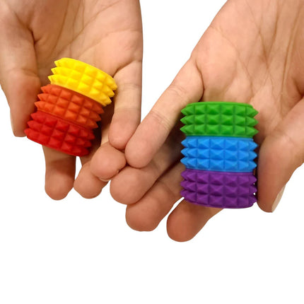 Hands holding colorful textured rings arranged in a rainbow stack, MagStak Core - Textured sensory fidget toy.