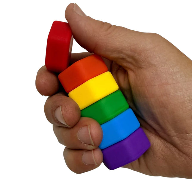 Hand holding colorful magnetic pieces stacked vertically, designed as MagStak Hive - Smooth sensory toy.