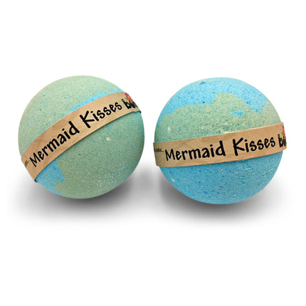 Two pastel blue and green bath bombs wrapped with a label reading Mermaid Kisses Coconut Lime Bubble Bath Bomb Set of 6