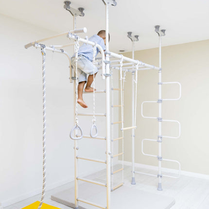 Child climbing white indoor gym set with rope and rings in bright room Ninja Home Play Set - No Drill