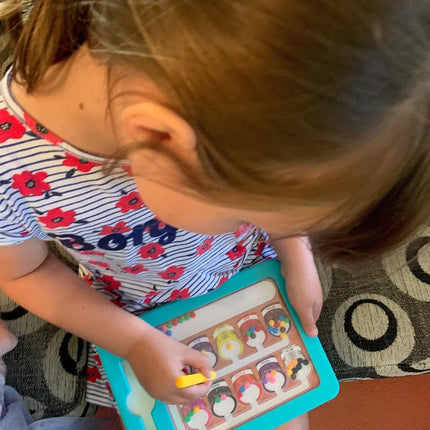Child playing with a Colour & Number Maze Magnetic Pad - Magnetic Colour Sorting Maze, placing colorful magnetic pieces on a blue-framed board.