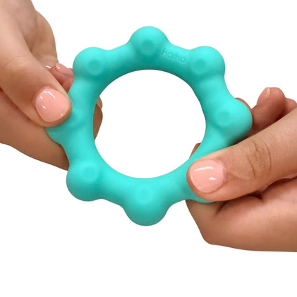Hands holding a teal sensory fidget ring toy designed for stress relief with Octopop - Quiet. Wearable. Satisfying text visible.