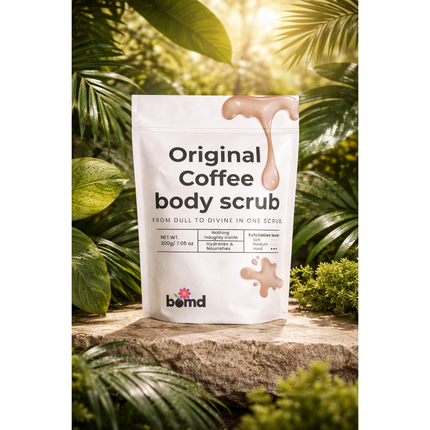 Coffee Body Scrub Original Warm Vanilla Blend package on stone surface with lush green tropical leaves background