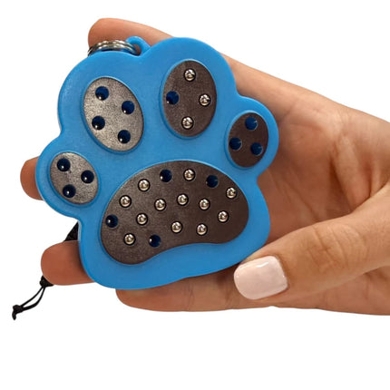 Hand holding a blue Paw Magnetic Pad Keyring shaped like a paw with silver magnetic dots on each pad section for sensory and stress relief use.