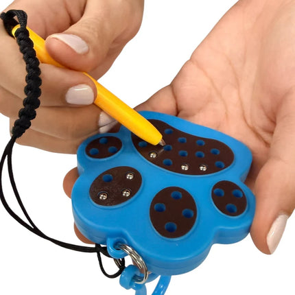 Person holding a blue Paw Magnetic Pad Keyring shaped like a paw with a yellow stylus interacting with the magnetic balls inside the paw-shaped pad.