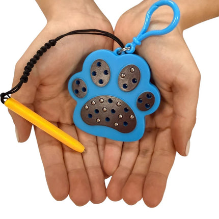Hands holding a blue Paw Magnetic Pad Keyring with a textured surface and attached yellow magnetic stylus, designed for sensory use.
