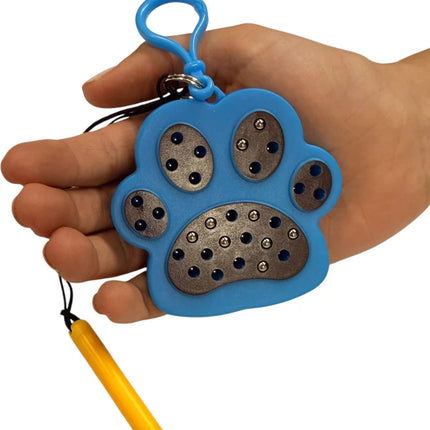 Hand holding a blue Paw Magnetic Pad Keyring shaped like a paw print, featuring multiple embedded magnets and a clip attachment.