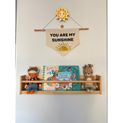 JORY W1 — Front-Facing Wall Bookshelf holding children’s books and toys under a "You Are My Sunshine" wall banner.