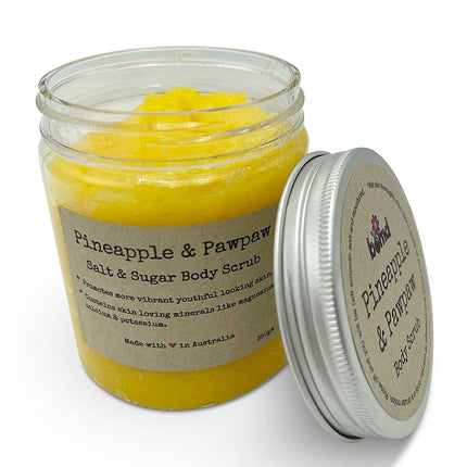 Jar of bright yellow Pineapple Papaya with Vitamin E Body Scrub with silver lid and natural brown label visible helping families thrive.