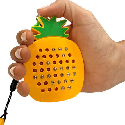Hand holding a bright yellow and green Pineapple Magnetic Pad Keyring with metal balls arranged in a grid for sensory play and fine motor skill engagement.