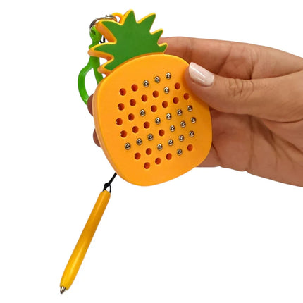 Hand holding a bright yellow and green Pineapple Magnetic Pad Keyring with small silver magnetic balls and a yellow stylus attached.