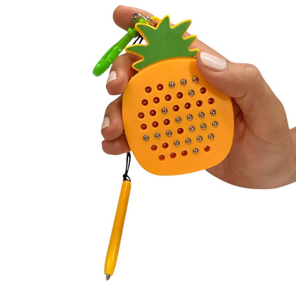 Hand holding a bright yellow and green pineapple-shaped Pineapple Magnetic Pad Keyring featuring small silver magnetic balls and a detachable yellow stylus pen.