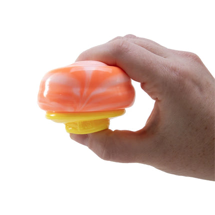 Hand holding an orange and yellow squishy sensory toy against a white background