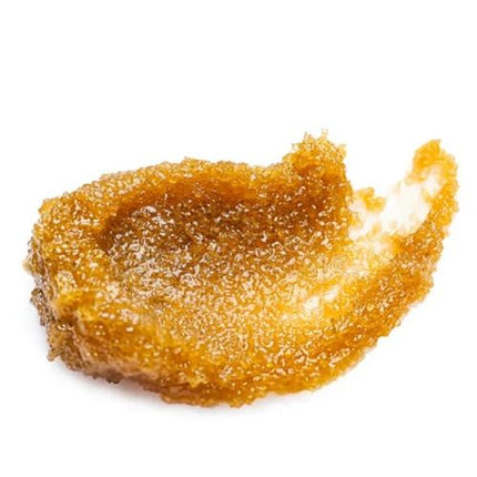 Close-up of golden exfoliating Salted Caramel Body Scrub with Vitamin E texture for sensory and skin care use.