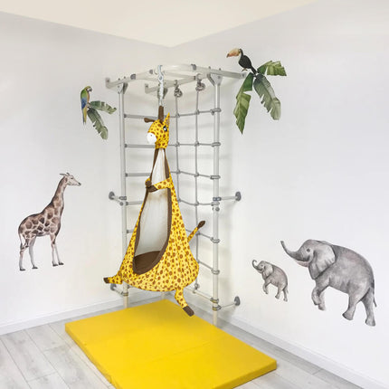 Sensory Swings hanging giraffe design with soft yellow mat, surrounded by animal wall decals, helping families thrive.