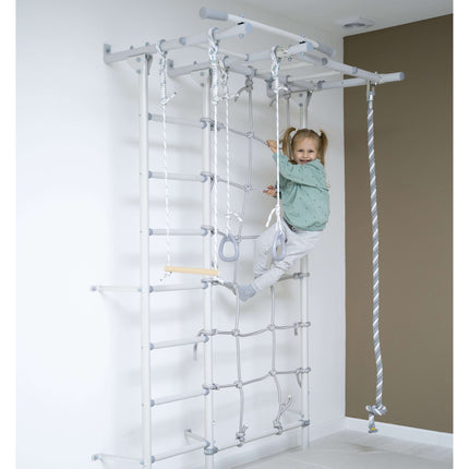 Child climbing and playing on white Swedish Giant Wallbars - S7 with rope and monkey bars indoors